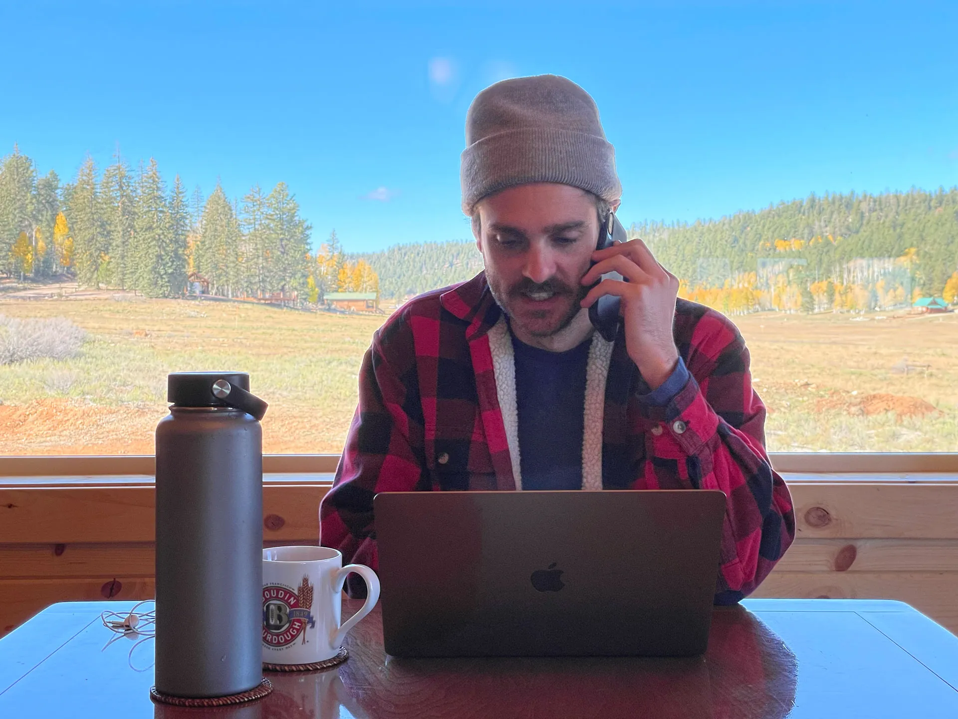 Alex in front of a laptop with trees in the background